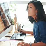 Designer working at a desktop with a graphics tablet, featured image from Best Web Design Agencies in Singapore