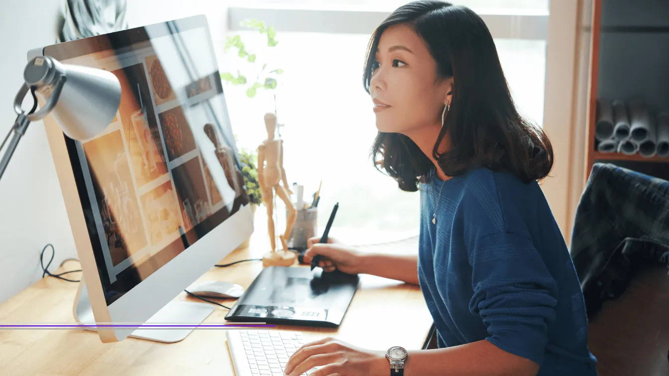 Designer working at a desktop with a graphics tablet, featured image from Best Web Design Agencies in Singapore