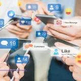 People holding smartphones with like, comment, and message overlays, featured image from Best Social Media Agencies in Singapore